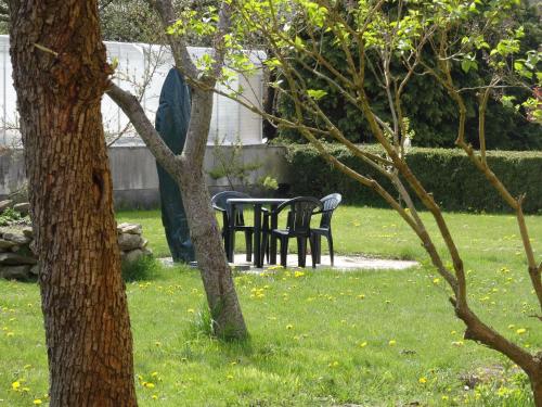 a table and chairs in a yard with trees at Apartment Zum Keulenbergblick in Laußnitz