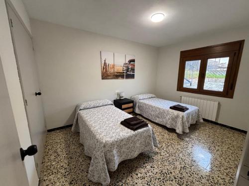 una habitación con dos camas y una ventana en Casa Ángeles, en Beceite