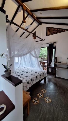 a bedroom with a bed with a mosquito net at Apartamento do Manu in Atins