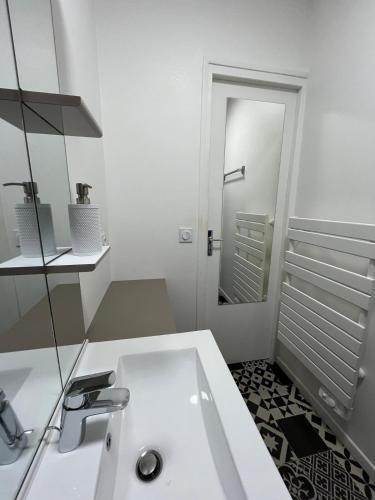 une salle de bain blanche avec un lavabo et un miroir dans l'établissement Annecy Old Town Lake Apartment, à Annecy