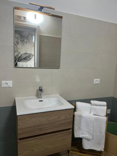 a bathroom with a sink and a mirror and towels at A CASA MIA in Sperlonga