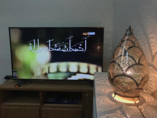 a television and a vase sitting in front of a lamp at Yellow House on the Nile in Luxor