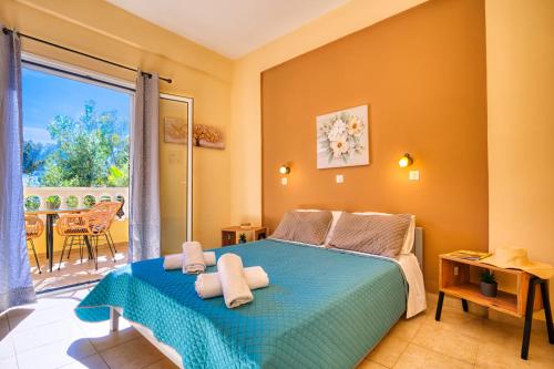 a bedroom with a blue bed and a balcony at Stefanias Prasoudi Beach in Ágios Matthaíos