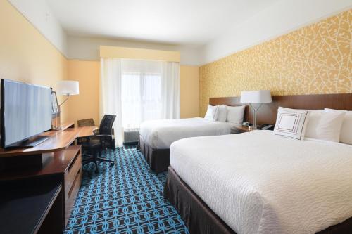 a hotel room with two beds and a flat screen tv at Fairfield Inn & Suites by Marriott Fort Worth South/Burleson in Burleson