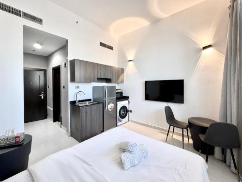 a bedroom with a bed and a kitchen with a tv at Al Manara Classic Deluxe Sheikh Zayed Studio in Dubai