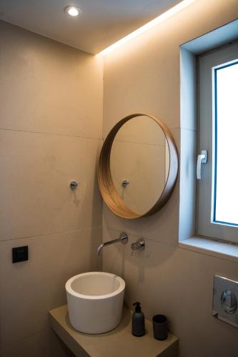 a bathroom with a sink and a mirror on the wall at Wabi Aegean Villa in Ios Chora