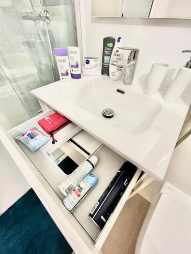 a bathroom vanity with a sink and toiletries at Scandi Apartment with Terrace and Parking in Karlsruhe