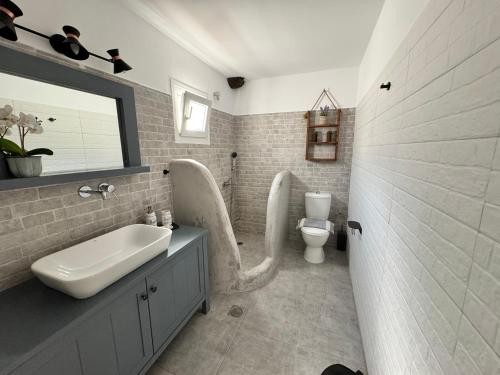 a bathroom with a sink and a toilet at Leonidas House Renovated 2024 in Agia Marina
