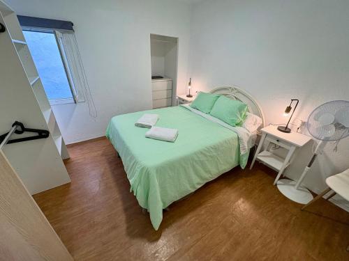 a bedroom with a bed with green sheets and a window at Ignis Rural Apartment - Casillas Valle de Ayora in Jalance