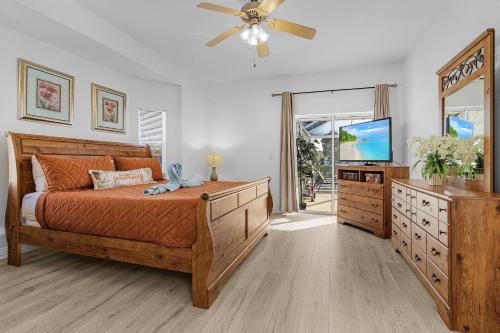 ein Schlafzimmer mit einem Bett und einem Flachbildfernseher in der Unterkunft Villa Lady Maria Relax W-Pool, Bbq Gulf Access in Cape Coral