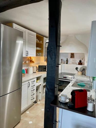 a kitchen with white cabinets and a stainless steel refrigerator at Villa Blanca Koukourava in Makrinitsa