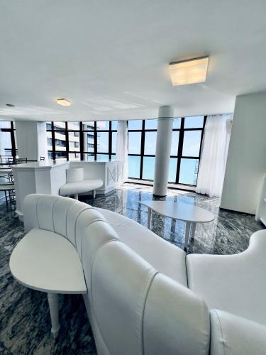 a living room with a white couch and tables at Hotel Brasil Tropical in Fortaleza