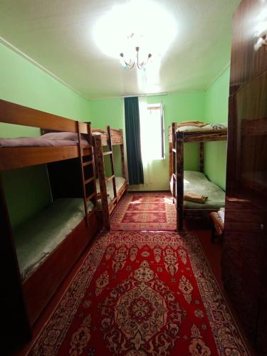 a room with three bunk beds and a red rug at Hostel 555 by VL in Alaverdi
