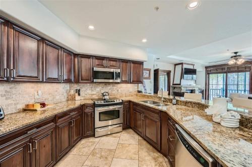 a large kitchen with wooden cabinets and appliances at Best Mtn View-Ski In Ski Out & Gondola to Downtown in Breckenridge