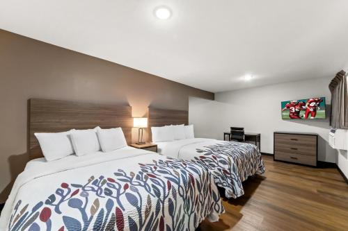 a hotel room with two beds and a tv at Red Roof Inn Del Rio in Del Rio