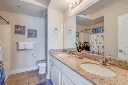 a bathroom with two sinks and a toilet at Crystal Tower 703 in Gulf Shores