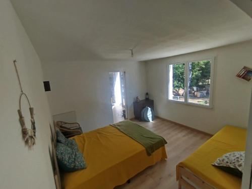 a bedroom with a bed and a window at Lodge détente nature Sam'Suffit in Oizé