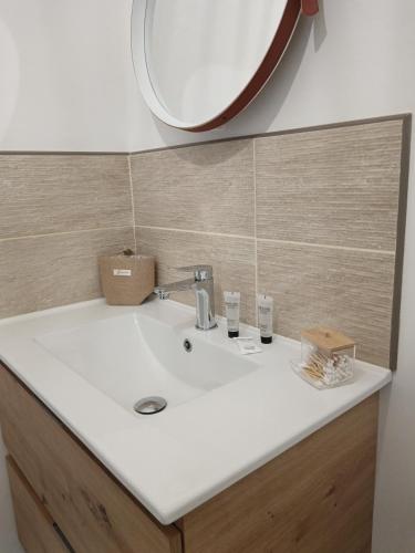 une salle de bain avec un lavabo blanc et un miroir dans l'établissement Studio tout confort avec place de parking et wifi, à Balaruc-les-Bains