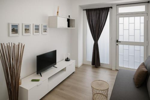 ein weißes Wohnzimmer mit einem Flachbild-TV auf einem Schrank in der Unterkunft Cómodo apartamento en Madrid climatizado in Madrid