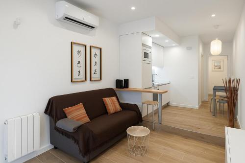 ein Wohnzimmer mit Couch und Küche in der Unterkunft Cómodo apartamento en Madrid climatizado in Madrid