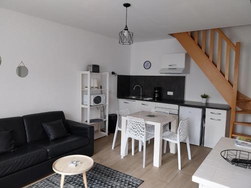 a living room with a black couch and a table at Maison de pêcheur idéalement située. in Le Tréport