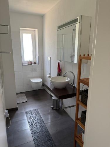 a white bathroom with a sink and a toilet at Three-castle-view in a new appartment in Neckarsteinach