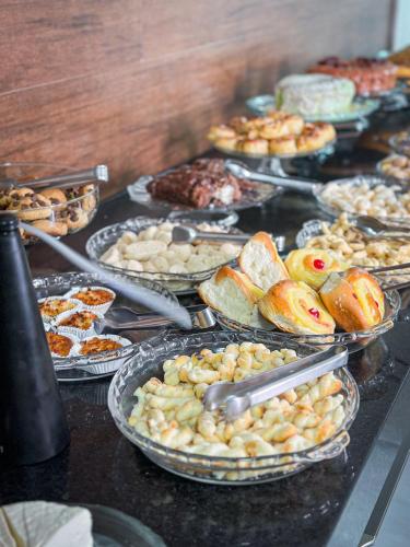 a buffet of different types of food on a table at Hotel Tropical Paracatu Ereli in Paracatu