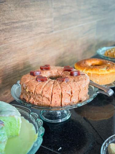 a cake on a glass plate on a table at Hotel Tropical Paracatu Ereli in Paracatu
