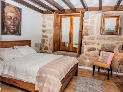 a bedroom with a king sized bed and a stone wall at Casa da Gandarela in Soajo