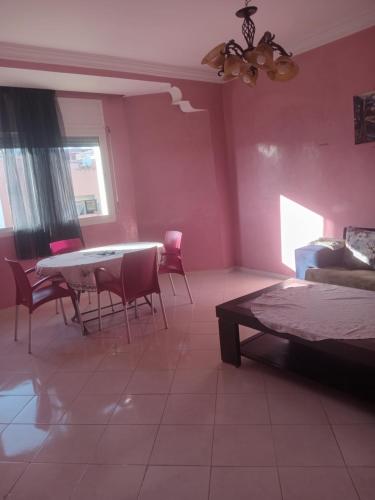 a bedroom with pink walls and a table and chairs at Appartement HASSANIA in Casablanca