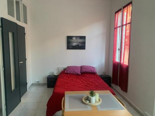 - une chambre avec un lit rouge et une table dans l'établissement Nice studio close to the sea, à Nice