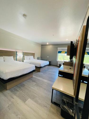 a hotel room with two beds and a television at Sonesta Essential North Houston in Houston