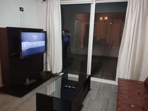 a living room with a tv and a coffee table at Hermosos departamentos en el centro de Coatepec Veracruz in Coatepec