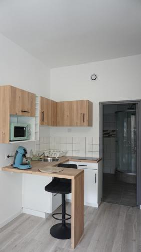 une cuisine avec des armoires blanches et une table en bois dans l'établissement Villars vibe & comfort, à Valenciennes