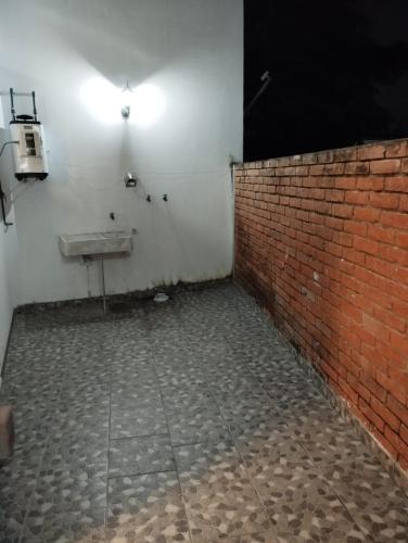 a bathroom with a brick wall and a sink at Hermosos departamentos en el centro de Coatepec Veracruz in Coatepec