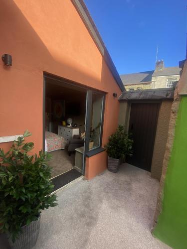 an orange building with a garage with a door open at Paddons Lodge in Tavistock