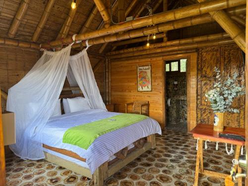 a bedroom with a bed in a log cabin at Jardin de los Silleteros Agro Parque Hotel in Santa Elena