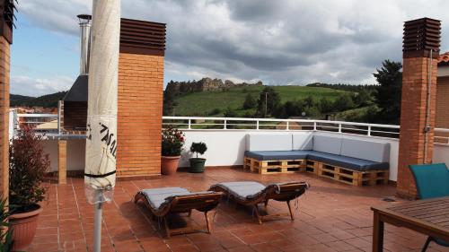 a patio with chairs and a bench on a balcony at La Loma de San Leonardo in San Leonardo de Yagüe
