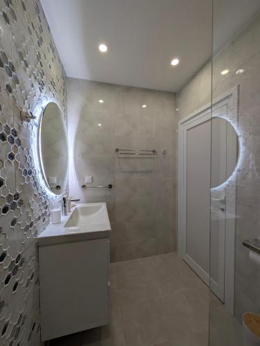 a bathroom with a shower and a sink and a mirror at Solea Suites in Chernomorets