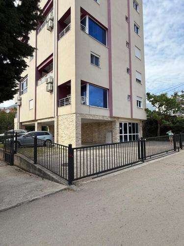 a tall building with a fence in front of it at DakiToki apartment in Kravlja