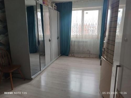 ein leeres Zimmer mit einer Tür und einem Fenster in der Unterkunft Жунисова 14 in Zhezdi