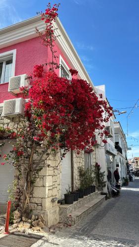 a building with red flowers on the side of it at Viyana otel in Cesme