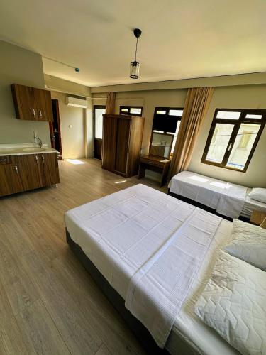 a large bedroom with two beds and a kitchen at Viyana otel in Cesme