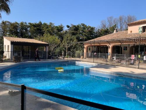 une grande piscine avec une personne marchant devant une maison dans l'établissement Séjour détente avec Piscine, à Hyères
