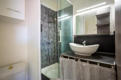 a bathroom with a sink and a glass shower at Studio Yellow Mood - Pond, Beach, Peace & Parking in Le Barcarès