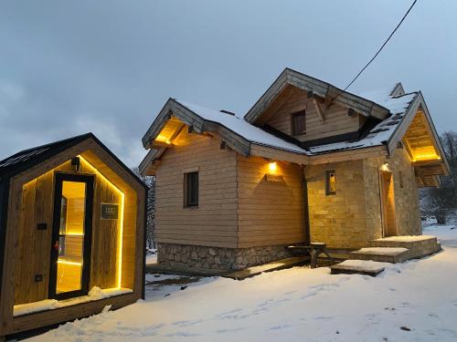 a cabin in the snow with lights on it at Planinska Koliba Exclusive in Sekulić 