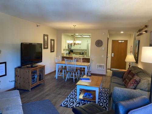 een woonkamer met een bank, een tv en een tafel bij Aspen Creek #226 Year-Round Activities in Mammoth Lakes
