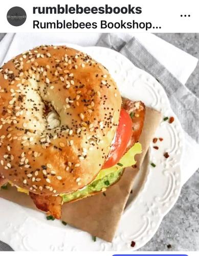 a bagel sandwich on a plate on a table at Upstairs at Rumblebees in Felsted Station