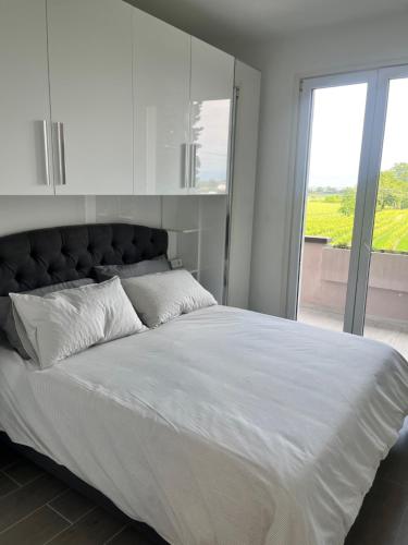 a bedroom with a large bed with a large window at Angy House 25 in Desenzano del Garda