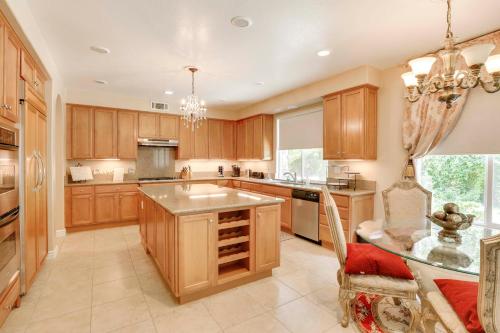 a large kitchen with wooden cabinets and a glass table at 2 Mi to Old Town Temecula Elegant SoCal Home in Temecula
